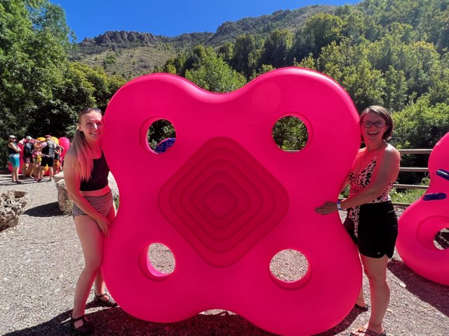 Two residents flanking a pink floatie