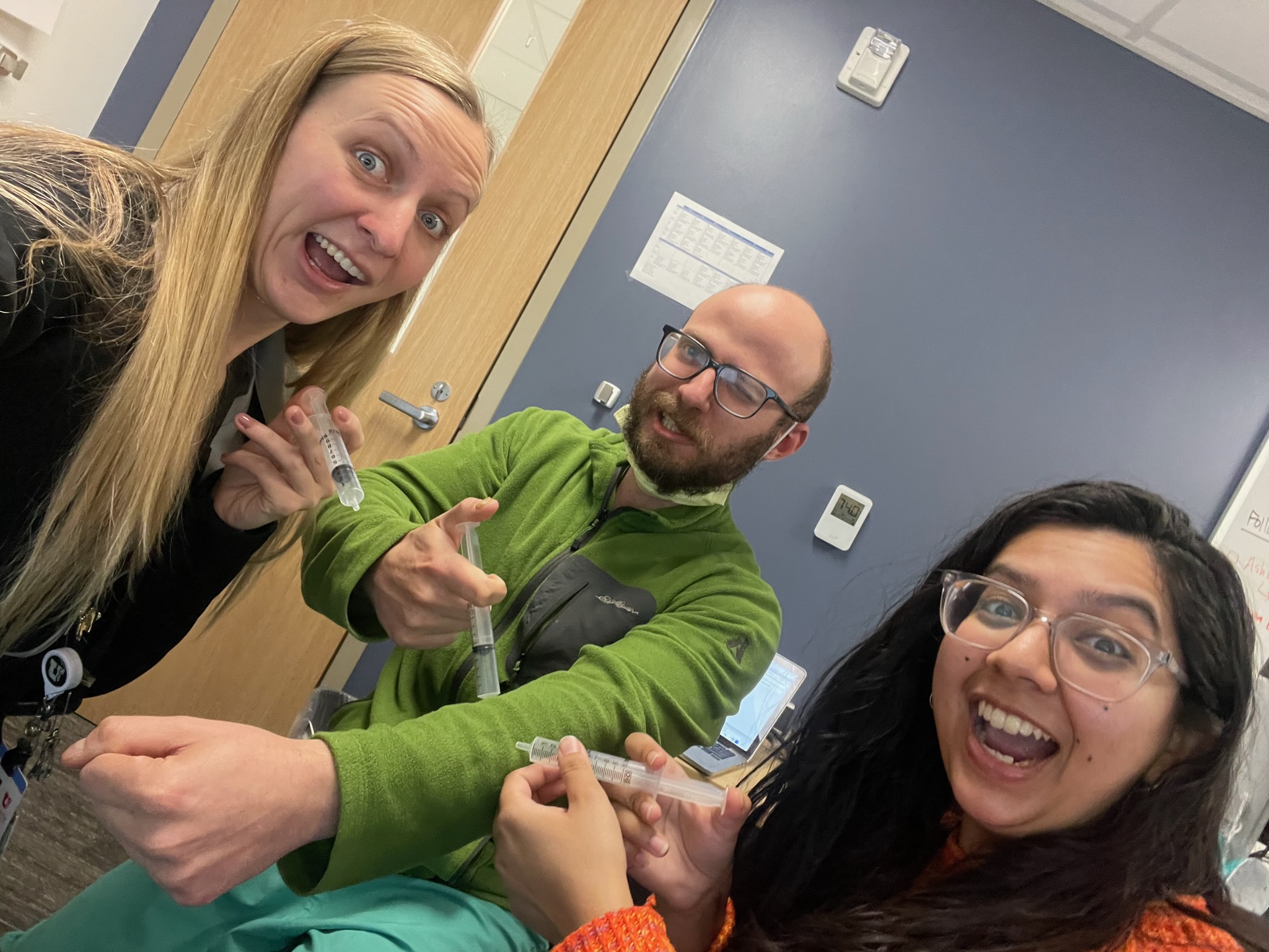 3 residents with silly expressions holding empty medicine applicators